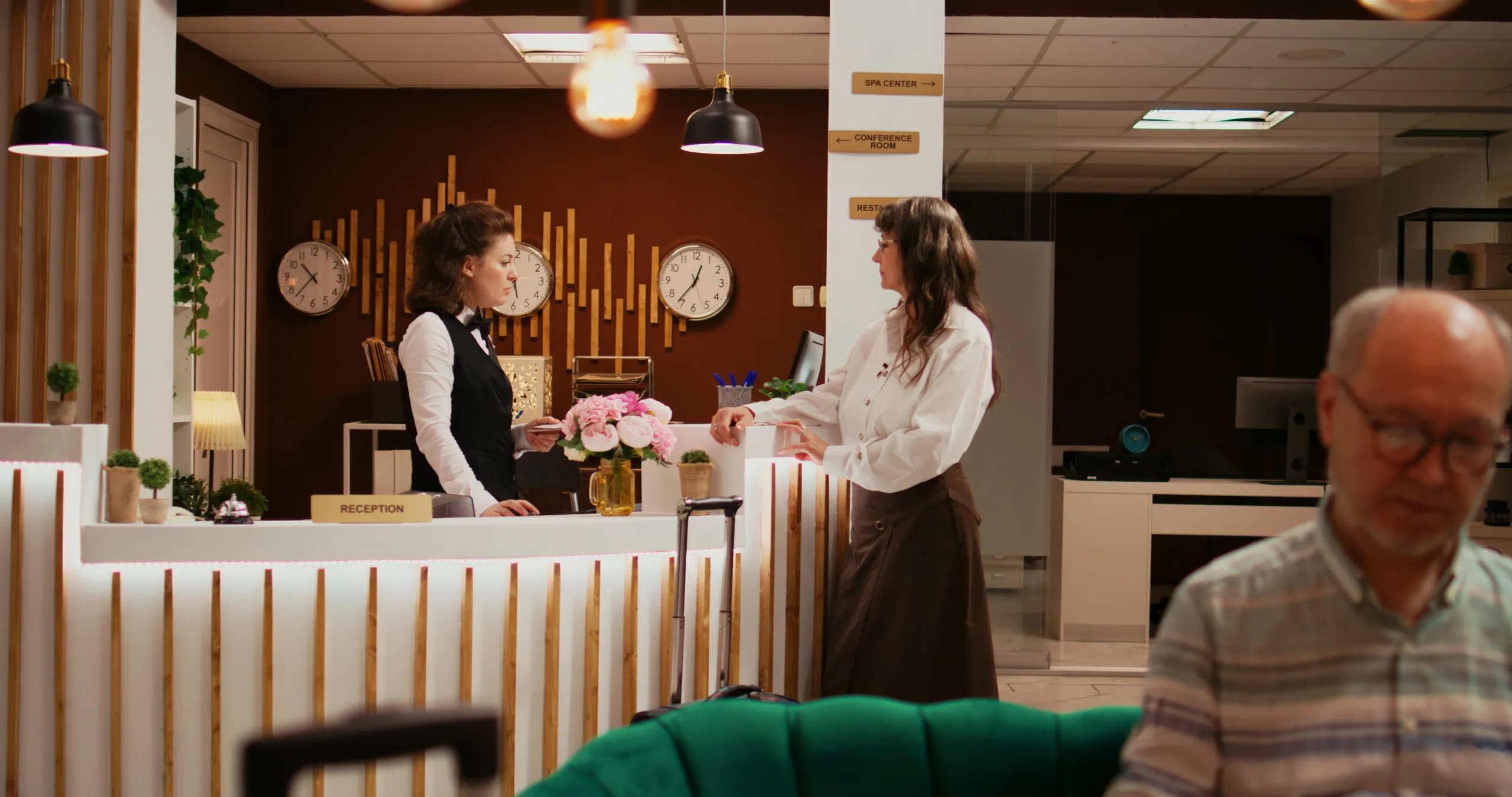 A guest being handed a room key card across the reception desk