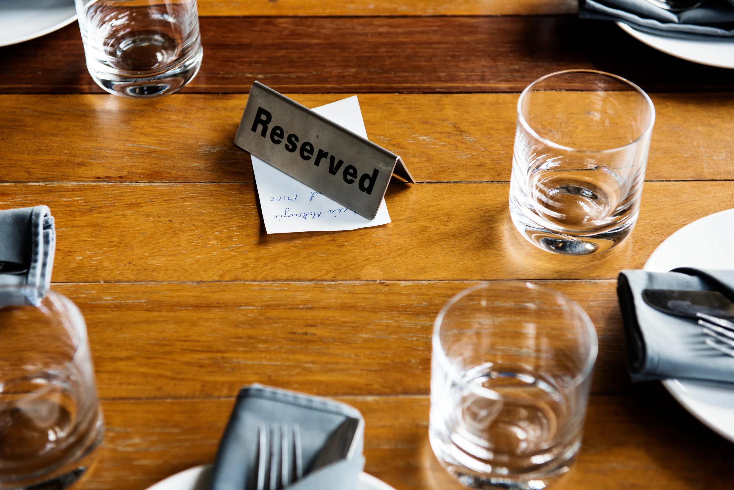A reserved card standing on a laid restaurant table