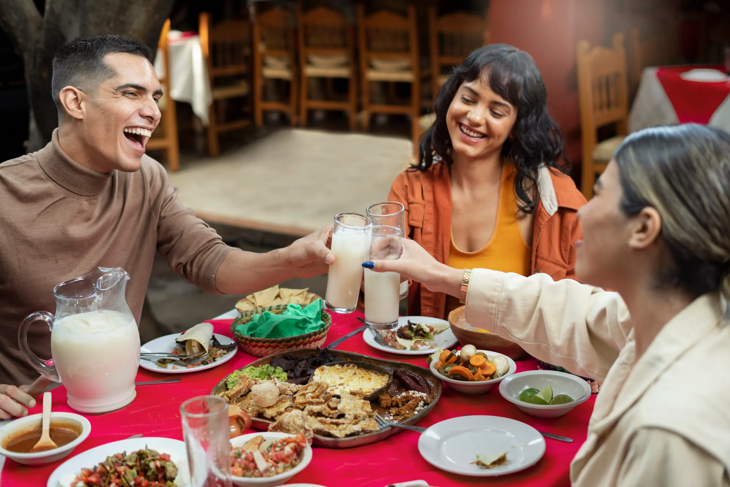 Friends sharing plates of food together at a restaurant table