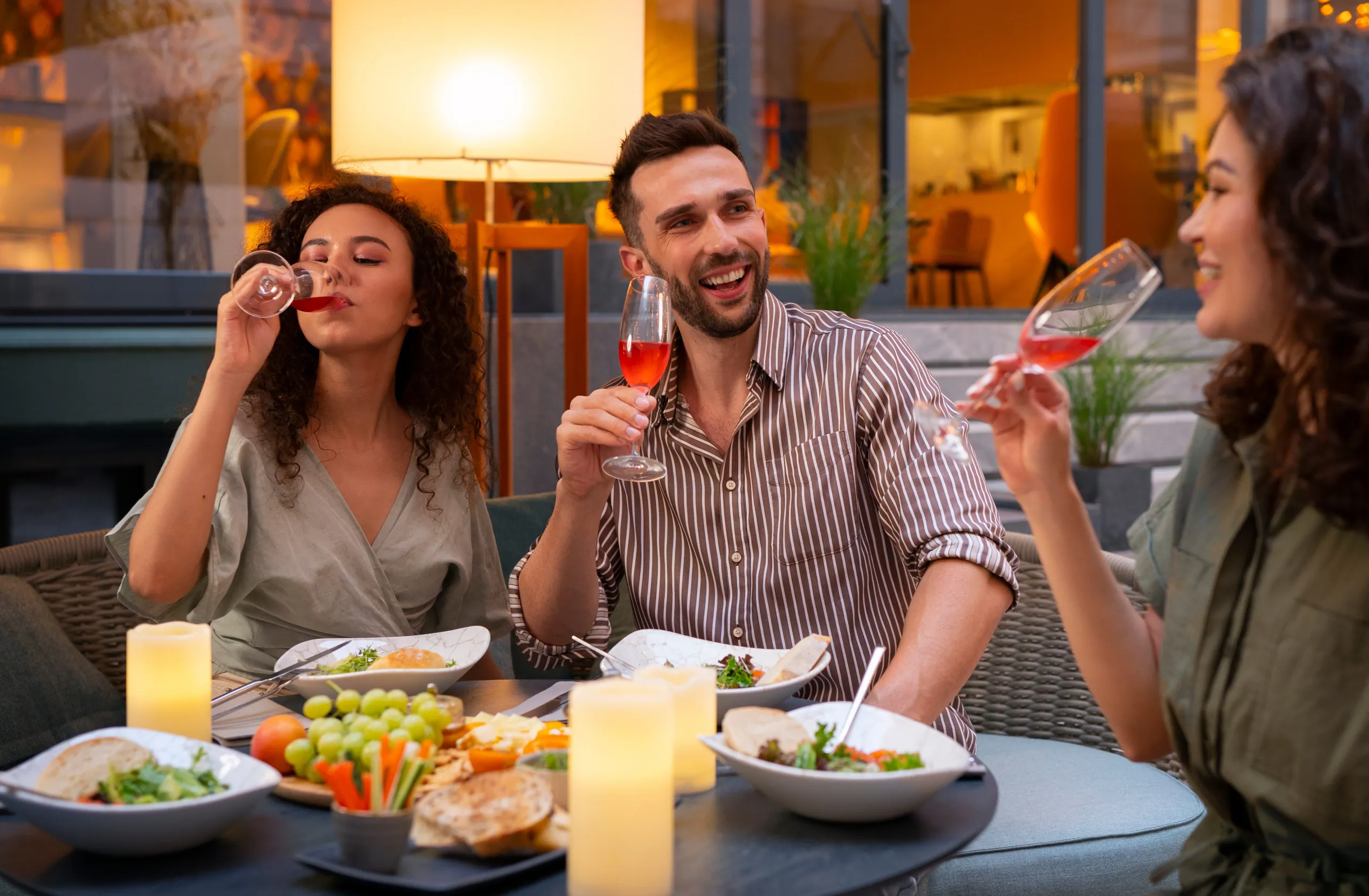 A group of friends raising their glasses around a dinner table